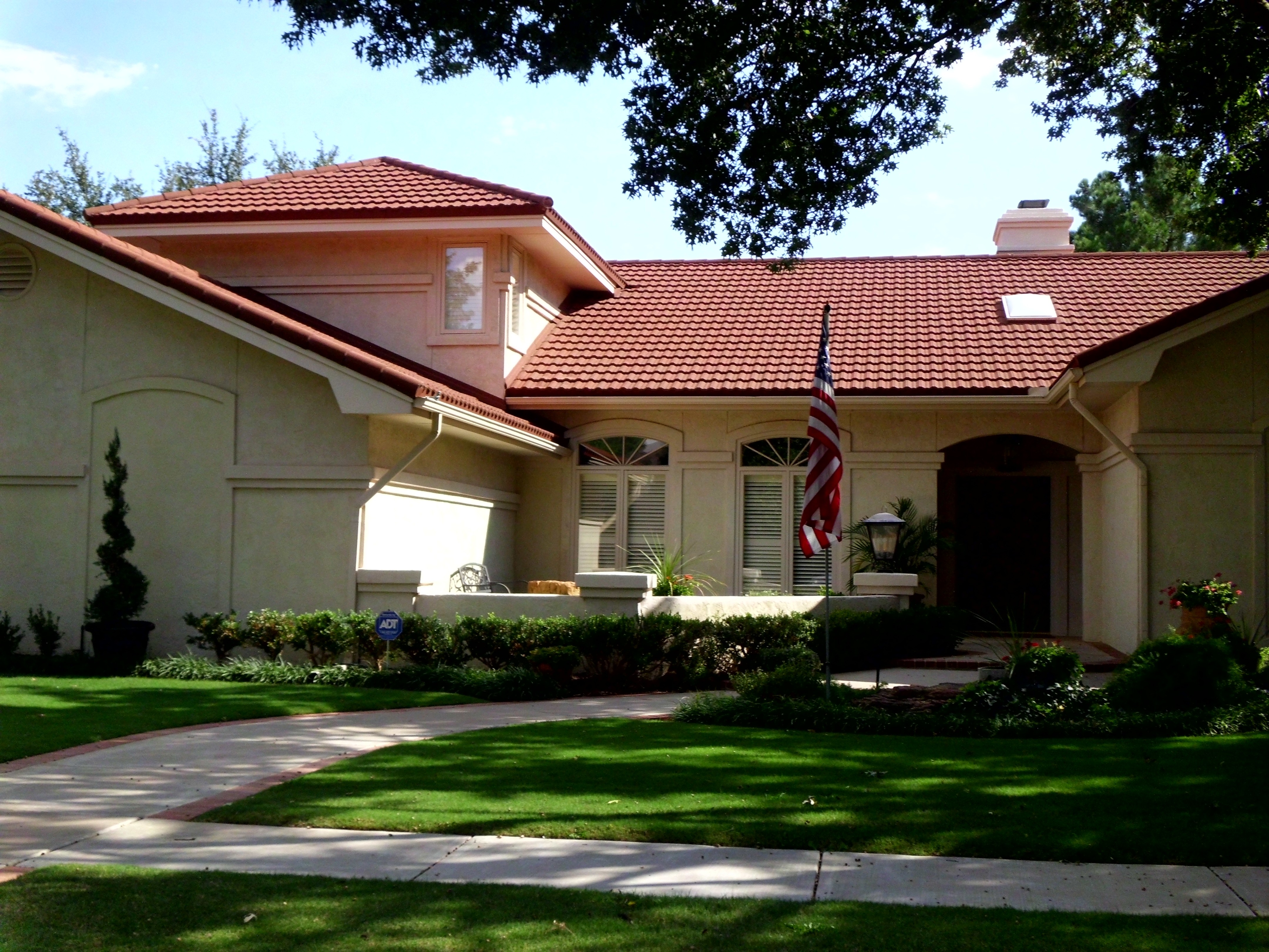Gerard Tile Terracotta stone-coated steel on stucco home with American flag